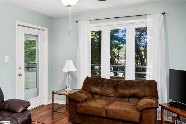 living area with baseboards and wood finished floors