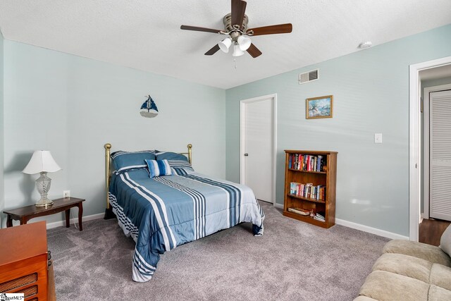 bedroom with carpet, visible vents, a textured ceiling, and baseboards