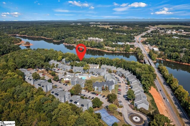 birds eye view of property with a water view and a wooded view