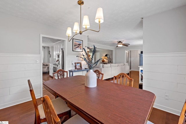 dining room with a textured ceiling, dark hardwood / wood-style floors, and ceiling fan with notable chandelier