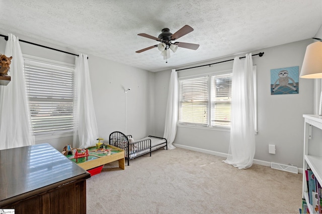 rec room featuring a textured ceiling, ceiling fan, and light carpet