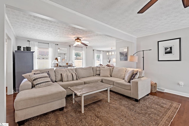 living room featuring crown molding, dark hardwood / wood-style flooring, ceiling fan, and a textured ceiling