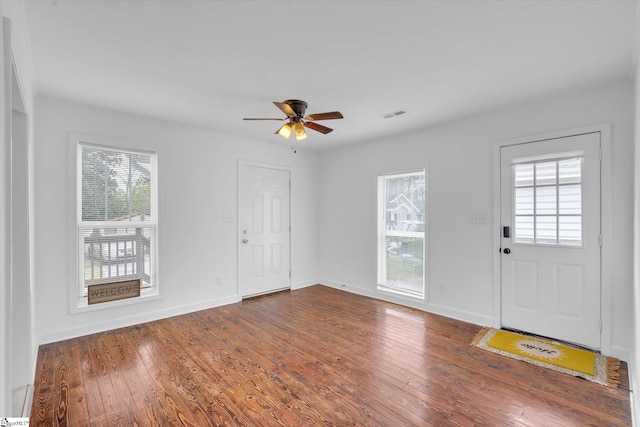 foyer entrance with a healthy amount of sunlight, ceiling fan, and dark wood-type flooring