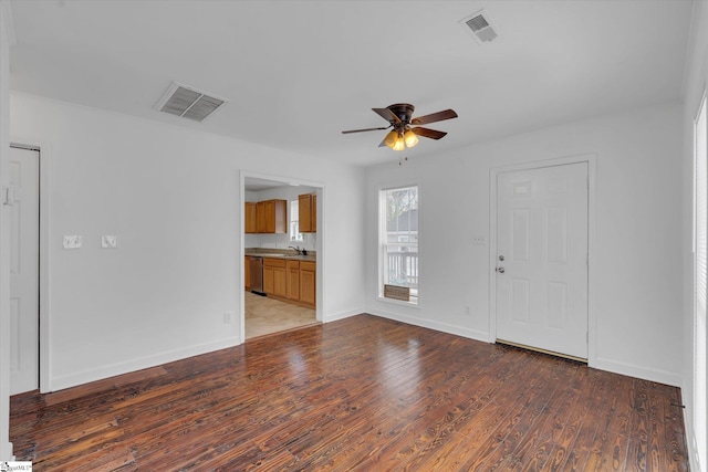 unfurnished living room with ceiling fan, sink, and hardwood / wood-style flooring