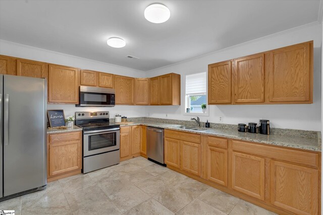 kitchen with light stone countertops, stainless steel appliances, crown molding, and sink