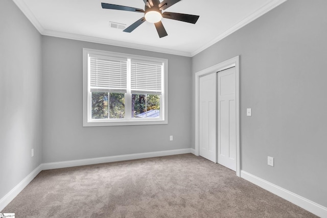 unfurnished bedroom with carpet flooring, a closet, ceiling fan, and crown molding