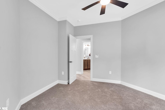 carpeted spare room with crown molding and ceiling fan