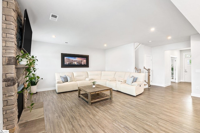 living room featuring light wood-type flooring and a fireplace