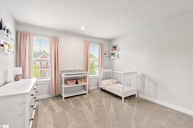 bedroom with light carpet and a crib