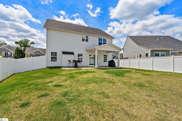 back of house with a patio area and a lawn