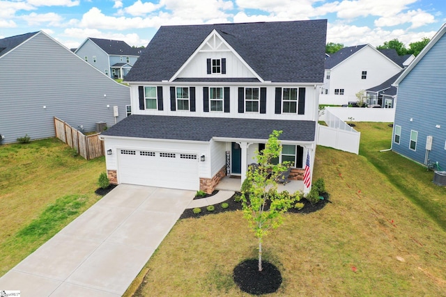 view of front of property with a garage, a front lawn, and central AC