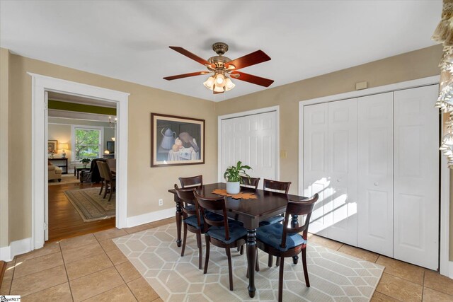 dining space with ceiling fan and light hardwood / wood-style flooring