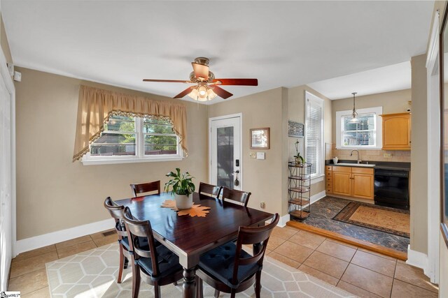 dining space featuring ceiling fan, light tile patterned floors, and sink