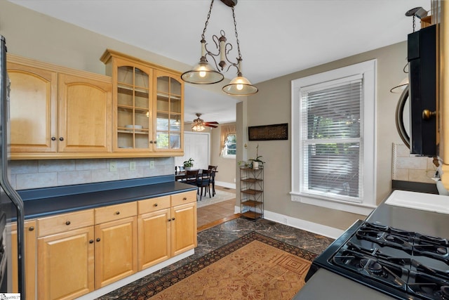 kitchen with hanging light fixtures, ceiling fan, dark tile patterned floors, and decorative backsplash