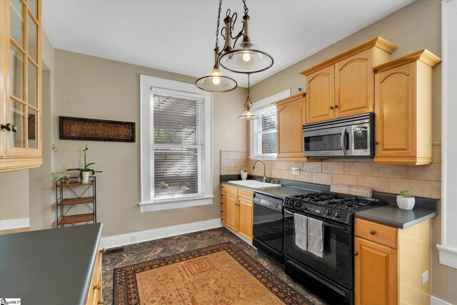 kitchen featuring black appliances, light brown cabinetry, tasteful backsplash, hanging light fixtures, and sink