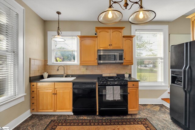 kitchen featuring a healthy amount of sunlight, black appliances, pendant lighting, and sink