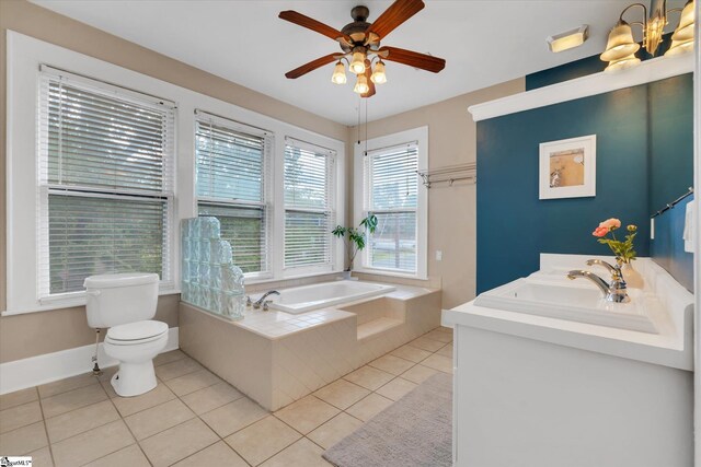 bathroom with toilet, tile patterned floors, vanity, a relaxing tiled tub, and ceiling fan