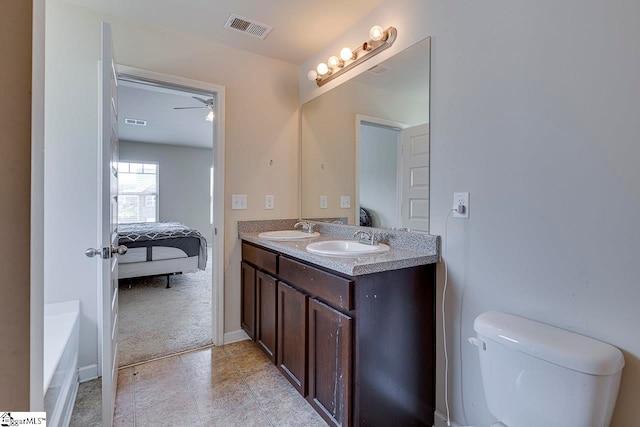 bathroom with vanity, toilet, and ceiling fan