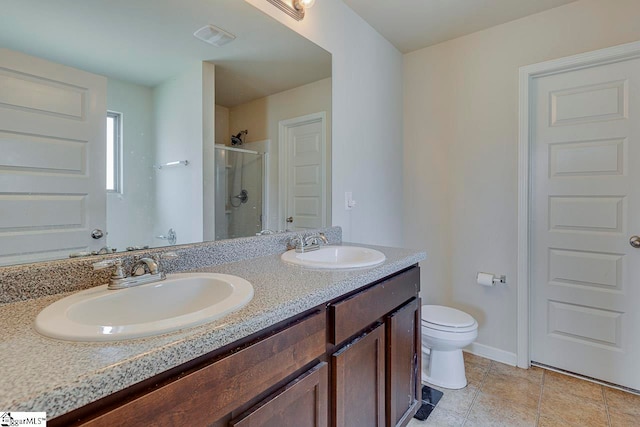 bathroom featuring tile patterned flooring, vanity, toilet, and a shower with shower door