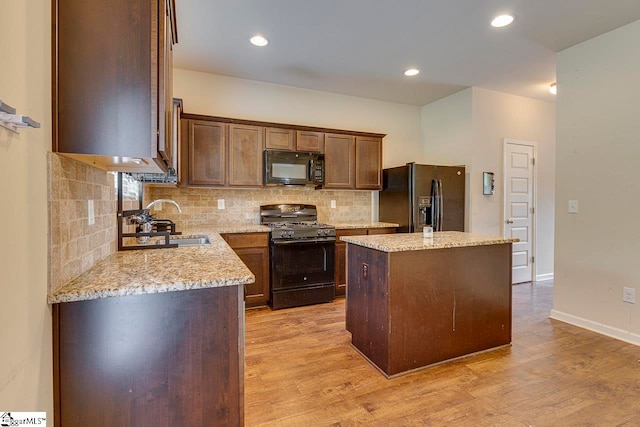 kitchen featuring black appliances, light hardwood / wood-style floors, sink, and a kitchen island