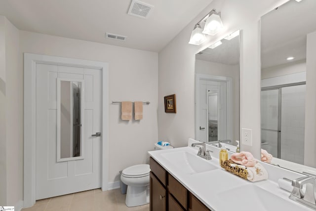 bathroom with vanity, toilet, tile patterned floors, and a shower with door