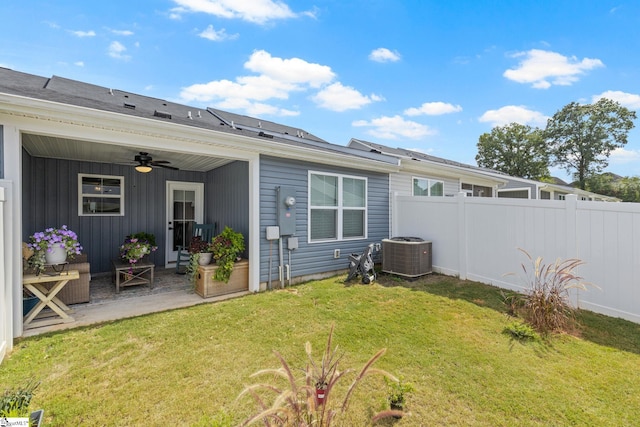 back of property with a lawn, ceiling fan, and cooling unit