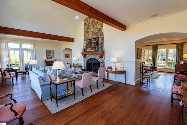 living room featuring vaulted ceiling with beams, dark hardwood / wood-style flooring, and a fireplace