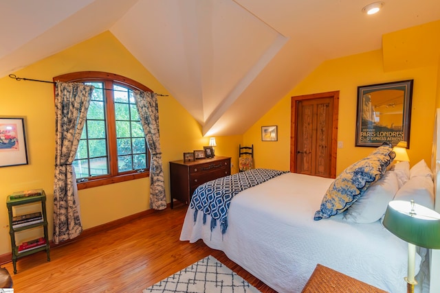 bedroom featuring hardwood / wood-style flooring and vaulted ceiling