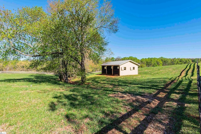 view of yard with a rural view and an outdoor structure