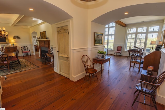 interior space with beam ceiling, dark hardwood / wood-style flooring, and ornamental molding