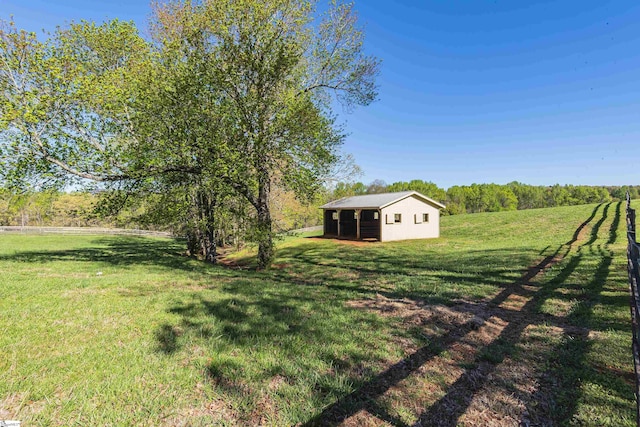 view of yard with a rural view and an outdoor structure