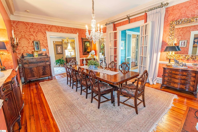 dining room featuring a notable chandelier, hardwood / wood-style flooring, and crown molding