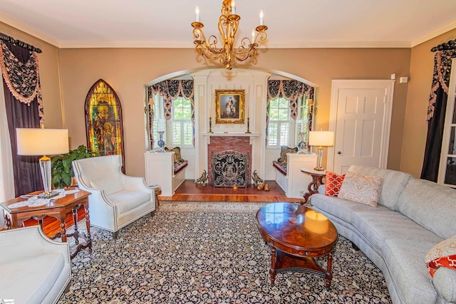 living room featuring a brick fireplace, a chandelier, and crown molding