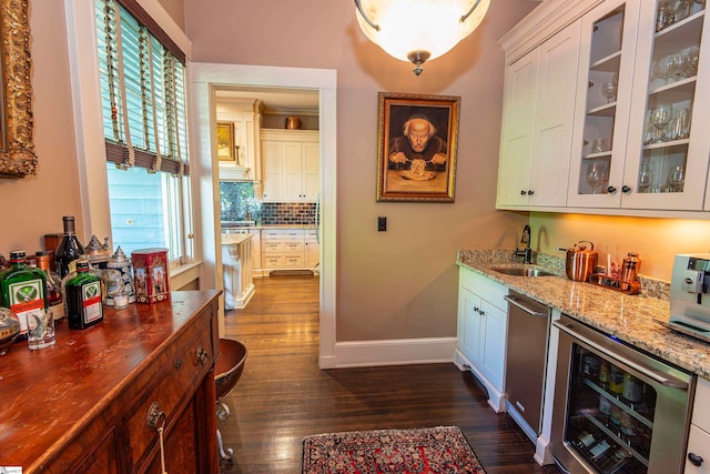 bar featuring dark wood-type flooring, tasteful backsplash, beverage cooler, and white cabinetry