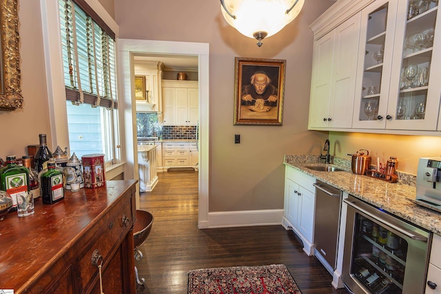571 E Main St, Spartanburg, SC 29302 - indoor wet bar with beverage cooler, dark wood-type flooring, baseboards, backsplash, and stainless steel dishwasher