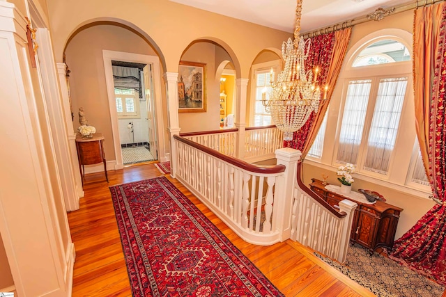 hallway featuring light wood-type flooring and a chandelier