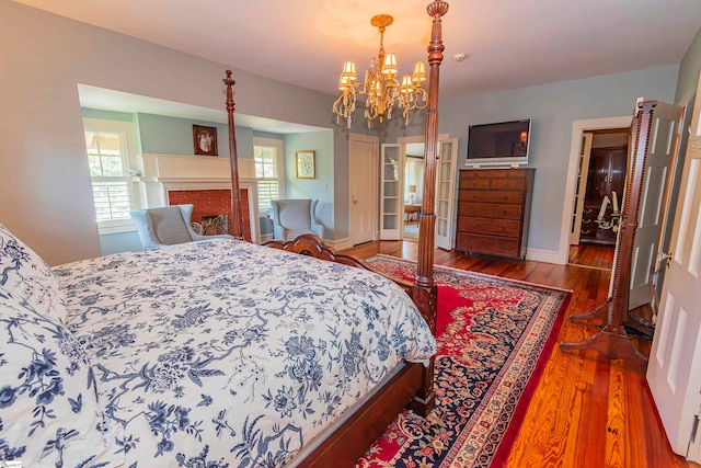 bedroom featuring an inviting chandelier, wood-type flooring, and a closet