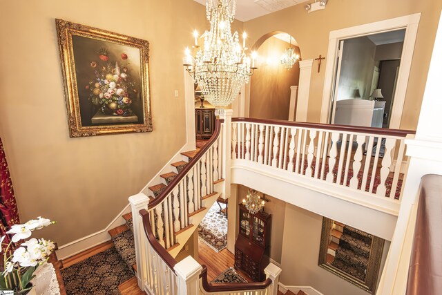 571 E Main St, Spartanburg, SC 29302 - stairs featuring arched walkways, a chandelier, and baseboards