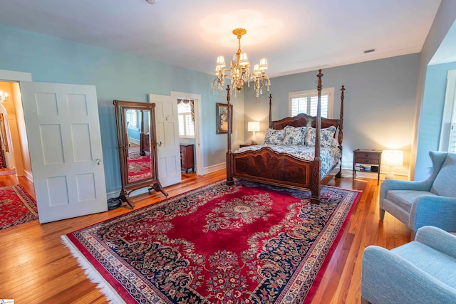 bedroom featuring hardwood / wood-style floors and a notable chandelier