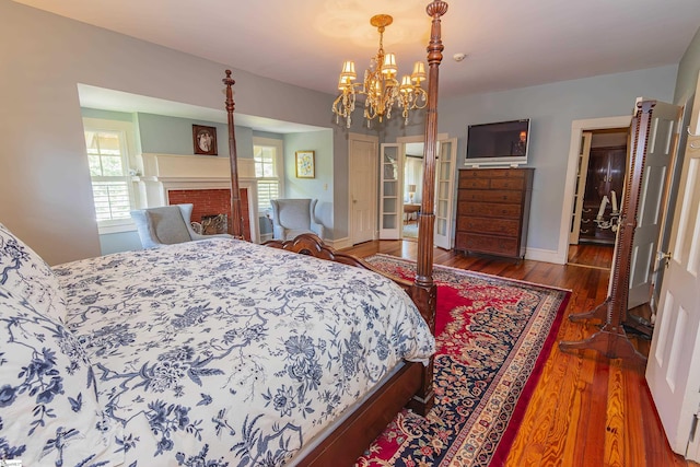 571 E Main St, Spartanburg, SC 29302 - bedroom featuring multiple windows, wood finished floors, a chandelier, and baseboards