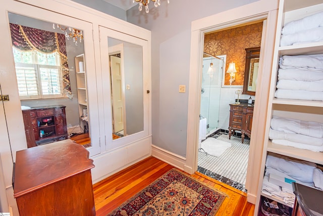 bathroom with a chandelier and wood-type flooring