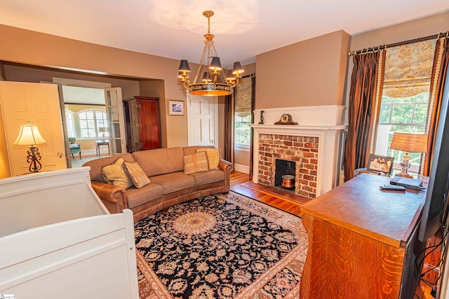 living room featuring hardwood / wood-style floors, a fireplace, and a notable chandelier