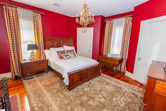 bedroom featuring a chandelier and wood-type flooring