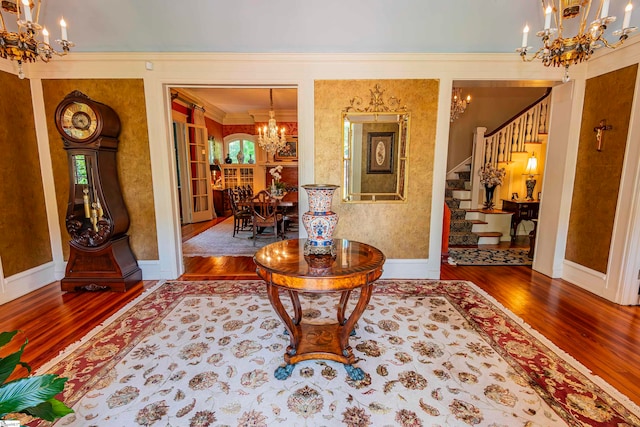 hall featuring an inviting chandelier, hardwood / wood-style flooring, and ornamental molding