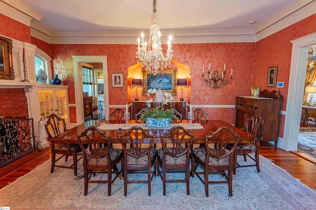 dining room with an inviting chandelier, hardwood / wood-style floors, and ornamental molding