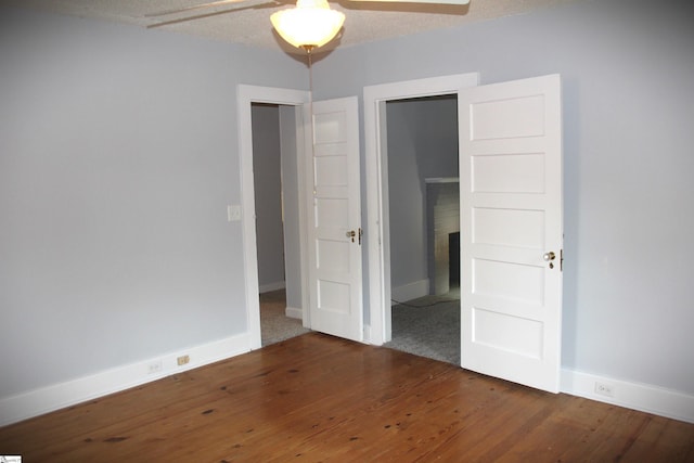 unfurnished bedroom with a closet, ceiling fan, dark hardwood / wood-style flooring, and a textured ceiling