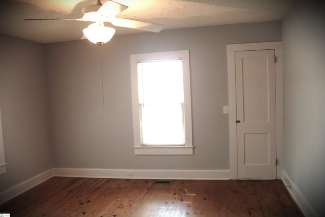 unfurnished room featuring a textured ceiling, dark wood-type flooring, and ceiling fan