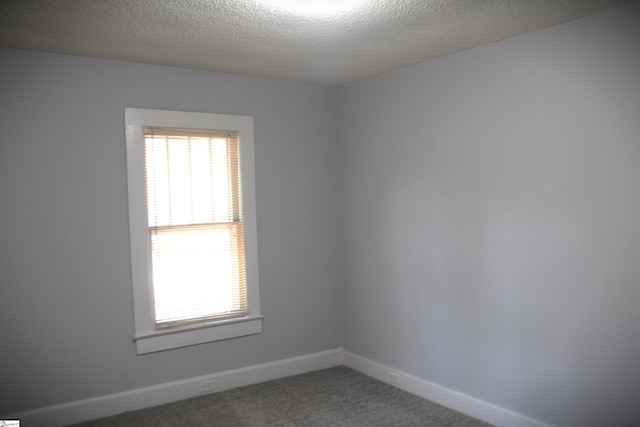 carpeted spare room with a textured ceiling