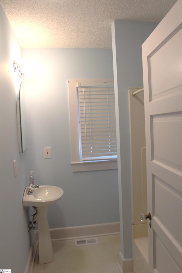 bathroom featuring separate shower and tub and a textured ceiling