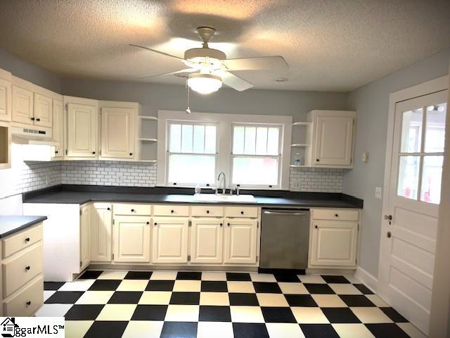 kitchen with white cabinetry, sink, ceiling fan, tasteful backsplash, and stainless steel dishwasher